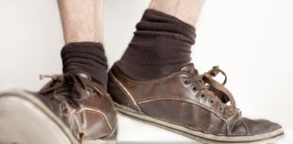 Uomo annusa calzini sporchi e puzzolenti